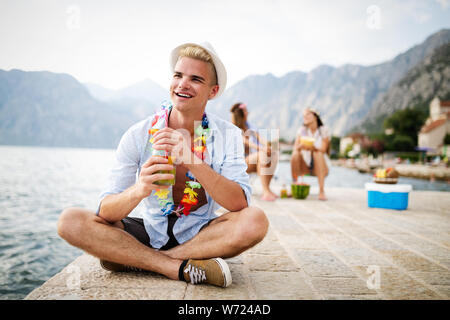 Junge Menschen glücklich mit Getränken entspannen am Strand Stockfoto