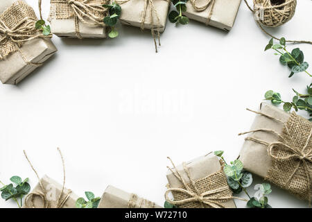 Geschenkboxen Sammlung in Kraftpapier Minimal Style mit Blättern auf weißem Hintergrund gewickelt. Für besondere Geschenk Konzepte Ideen. Flach template Design Stockfoto