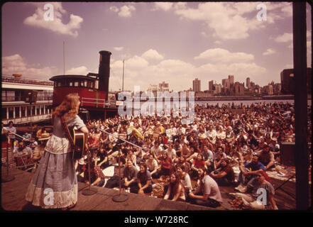 FOLK Singen und Tanzen HAT EIN NEUES ZUHAUSE GEFUNDEN AM South Street Seaport auf dem East River in der Nähe der Brooklyn Bridge. Begeisterte Zuschauer versammeln sich mehrmals in der Woche während des Sommers ZU GENIESSEN DIE SHOW UND DIE MUSIK, Blick auf den Hafen, Boote, und atmen Sie die Luft Stockfoto