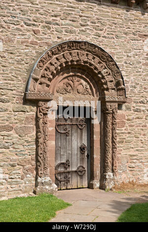 Arch mit kunstvollen Schnitzereien über Süden Tür. Einschließlich der Engel in der Mitte. Kirche St. Maria und St. David, Kilpeck, Herefordshire Stockfoto