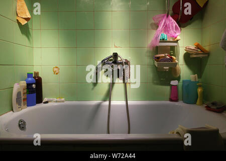 Details eines alten Bad, Wanne und Zubehör, schmutzig und alt Fliesen. Stockfoto