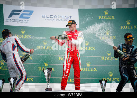 Nobuharu Matsushita von Japan, Mick Schumacher von Deutschland und Sergio Sette Camara Brasiliens feiern auf einem Podium nach dem zweiten Rennen der FIA Formel 2 Meisterschaft auf dem Hungaroring in Budapest. Stockfoto