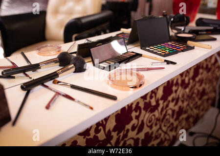 Für Make-up. Make-up-Tabelle mit Bürsten, Mascara, Korrektor, Pudding ausbreiten. Stockfoto