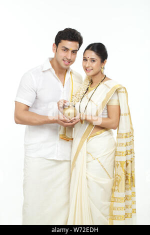 Südindische Frau, eine Münze in ein Sparschwein mit ihrem Ehemann Stockfoto