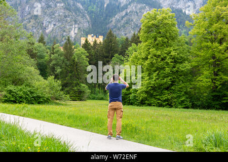 24. Mai, 2018. Schloss Hohenschwangau, Bayern, Deutschland. Tourist, Foto per Handy von berühmten deutschen Schloss Hohenschwangau. Feder. Stockfoto