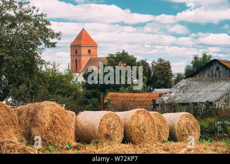 Mir, Belarus. Herbst Heuballen und Saint Nicolas Römisch-katholische Kirche im Hintergrund. Mir, Belarus. Kulturelles Denkmal und Wahrzeichen. Stockfoto