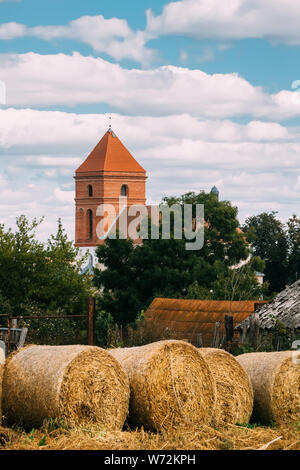 Mir, Belarus. Herbst Heuballen und Saint Nicolas Römisch-katholische Kirche im Hintergrund. Mir, Belarus. Kulturelles Denkmal und Wahrzeichen. Stockfoto