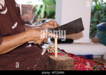 Frau Teilen einer Stick aus Bambus Holz mit einem Messer in Papier Regenschirm Factory in Chiang Mai, Thailand Stockfoto