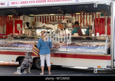 Eine Frau mit Scotch Collie am Fleisch Stall in der der Markt in den Place Guillaume II in Luxemburg. Stockfoto