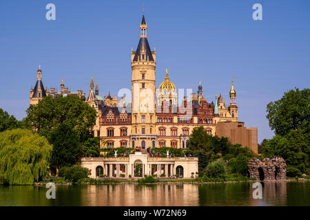 Foto von Schloss Schwerin, vom See aus gesehen; Touristen gesehen werden kann zu Fuß auf das Gelände. Stockfoto