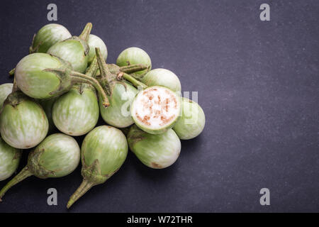 Ansicht von oben Frische grüne Thai Auberginen auf schwarzen Stein Hintergrund Stockfoto