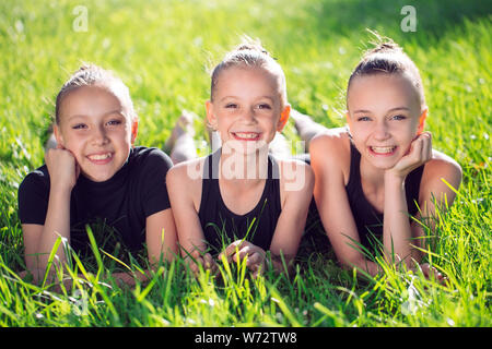 Drei Mädchen liegend im Gras und Spaß zu haben. Stockfoto