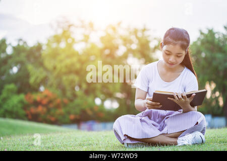 Hübsche Asiatin oder Studenten ein Buch lesen in den öffentlichen Park. Bildung oder entspannen Sie sich mit dem Begriff Stockfoto