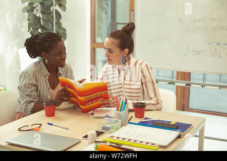 Aufmerksamen jungen weiblichen Person an ihrem Lehrer suchen Stockfoto