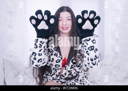 Asiatische Mädchen trägt Katze Pfote Handschuhe für Cosplay auf weißem Hintergrund Stockfoto