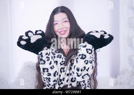 Asiatische Mädchen trägt Katze Pfote Handschuhe für Cosplay auf weißem Hintergrund Stockfoto