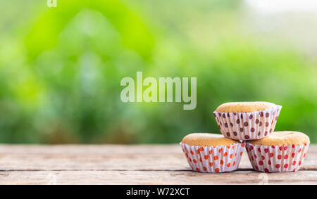 Alte Ei Kuchen in Pappbecher auf Holztisch mit grüne Natur leichte Unschärfe Hintergrund und Platz für Text, Design, Fotomontage oder Werbung Stockfoto