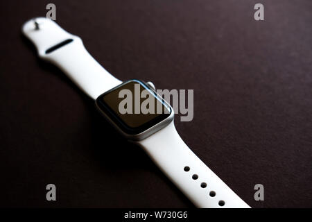 Tschechow, Russland - Juli 19, 2019: Apple Watch Serie 4 weiße Farbe. Eine neue Uhr aus der Firma Apple closeup auf dunklem Hintergrund isoliert Stockfoto