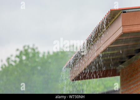 Regen, nach unten fließt aus dem Dach Haus in der Regenzeit Stockfoto