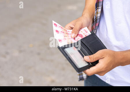 Asiatische Touristen zählen oder die Überprüfung der Banknoten in schwarz Brieftasche, die er in Die touristische Attraktion gefunden Stockfoto