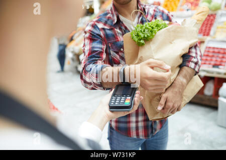 Nahaufnahme des unkenntlich Mann zahlen über smartwatch beim Einkaufen bei Farmers Market, Kopie Raum Stockfoto