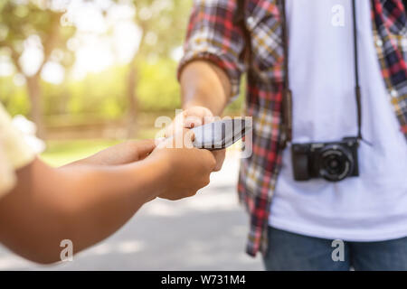 Asiatische Touristen herauf seine schwarzen Mappe von anderen Menschen, dass sie in der Touristenattraktion gefunden. Wallet Konzept zu verlieren. Stockfoto
