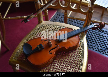 Violine ruht auf einem Stuhl Stockfoto