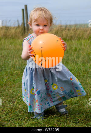 Kleinkind spielen mit einem Ball, Großbritannien Stockfoto