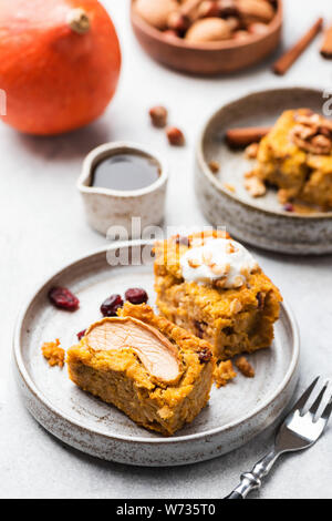 Frühstück Kürbis Apfelkuchen mit Preiselbeeren auf Platte garniert mit Sahne Walnüsse und Ahornsirup. Selektiver Fokus Stockfoto