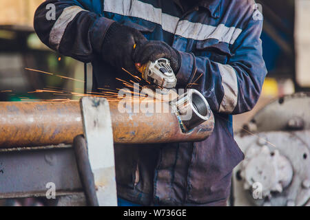 Arbeitnehmer in einer Gießerei schleifen Gussteile mit Schleifmaschine - Schwerindustrie Arbeitsplatz. Stockfoto