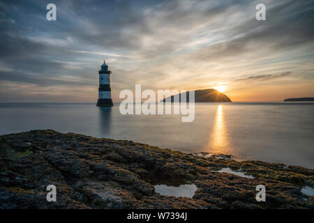 Schönen Sommer Sonnenaufgang über Puffin Island (ynys Seiriol) und Trwyn Penmon Point (Du) Leuchtturm, Anglesey, Wales, Vereinigtes Königreich Stockfoto