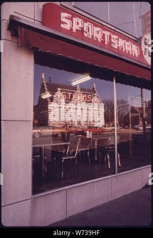 Die POST in New Ulm, Minnesota, SPIEGELT SICH IN DEM FENSTER DER SPORTLER CAFE ÜBER MITTE STRASSE. Die Struktur wurde errichtet, 1909-10 UND IST ALS National Historic Site WEGEN SEINES DESIGNS registriert. Steilen DACH, abgestufte Giebel, dekorativen DETAILS UND DIE KOMBINIERTE VERWENDUNG VON ZIEGEL UND STEIN DER DEUTSCHEN renaissance Stil, DIE IHREN URSPRUNG IN FRANKREICH UND DEN NIEDERLANDEN widerspiegelt. Das Gebäude FÜGT SICH MIT ANDEREN IN DIESER STADT, gegründet von deutschen Einwanderern Stockfoto