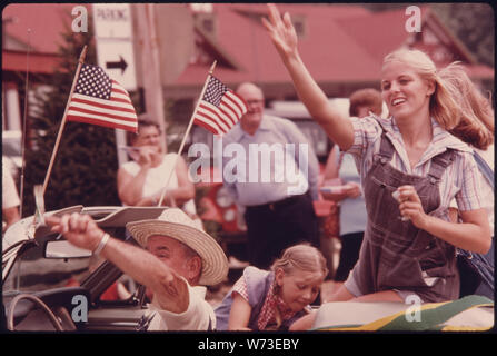 Weiße Grafschaft BEAUTY QUEEN (ARBEITSANZUG) und ihrem Fahrer werfen, KAUGUMMI UND SÜSSIGKEITEN IN DIE MENGE FUTTER DIE HAUPTSTRASSE VON HELEN GEORGIA, in der Nähe von ROBERTSTOWN WÄHREND EIN VIERTEL DER JULI PARADE. HELEN WAR EIN TYPISCHES, kleines Bergdorf VON WENIGER ALS 300 Menschen bis Anfang 1969 als Stadt Beamte, Geschäftsleute und Bewohner unterstützt RENOVIERUNG DES GESCHÄFTSVIERTELS MIT EINEM BAYERISCHEN ALPINE THEMA DAS PROJEKT WAR EIN ERFOLG UND ZOG NEUE UNTERNEHMEN UND EINE SCHWANKUNG DER TOURISTEN Stockfoto