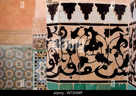 Medersa Ben Youssef - Marrakech, Marokko. Detail der Stuck Schnitzereien, Fliesen und Arabische Kalligraphie schmücken die Wände der Innenhof. Stockfoto