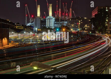London Bahn Light Trails mit Battersea Park Kraftwerk, Bau Kräne im Hintergrund in England, Großbritannien Stockfoto