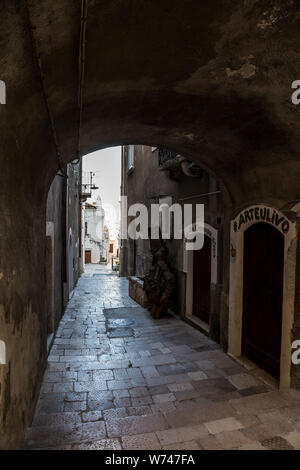 Enge Straßen mit Treppen, weiße Häuser und Blumen in Peschici. Schöne Architektur Gebäude Exterieur im historischen Zentrum, Gargano, Italien Stockfoto