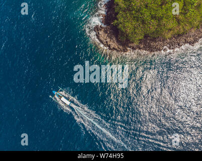 Meer Bucht mit türkisfarbenem Wasser und einem kleinen weißen Strand. Schöne Lagune und Insel vulkanischen Ursprungs mit dichtem Wald bedeckt, Ansicht von oben Stockfoto