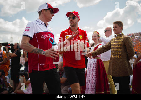 Alfa Romeo Racing der Finne Kimi Räikkönen (L) und die Scuderia Ferrari die deutschen Fahrer Sebastian Vettel die Treiber Parade teilnehmen vor, bevor die Ungarische F1 Grand Prix am Hungaroring. Stockfoto