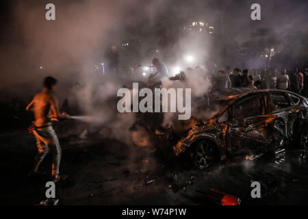 Kairo, Ägypten. 05 Aug, 2019. Leute, ein Feuer zu löschen, nachdem eine Explosion vor dem National Cancer Institute. Nach Angaben des Gesundheitsministeriums mindestens 17 Menschen ums Leben gekommen und 26 verletzt worden. Credit: Omar Zoheiry/dpa/Alamy leben Nachrichten Stockfoto