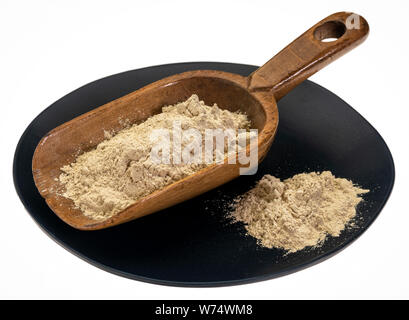 Ashwagandha root (aka Indischer ginseng) Puder auf rustikalen Holzmöbeln Schaufel gegen isolierte schwarze Platte Stockfoto