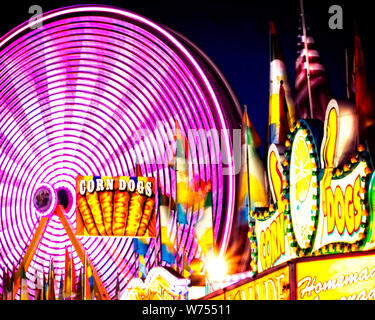 Eine sich drehende Riesenrad mit wechselnden Farben ist das Herzstück der Midway zu einem County Fair. Stockfoto