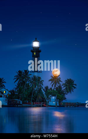 Einen schönen Vollmond steigt an der Hillsboro Inlet Leuchtturm in Südflorida. Es ist ein historisches Wahrzeichen und wurde erstmals im Jahr 1907 beleuchtet. Stockfoto