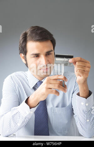 Unternehmer, die eine Kreditkarte mit einer Schere schneiden Stockfoto