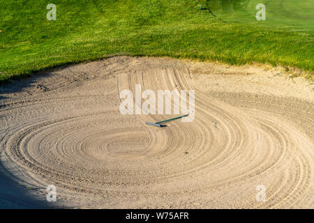 In der Nähe von Golfplatz sand Bunker mit einem kreisförmigen Muster durch die Rechen erstellt Stockfoto