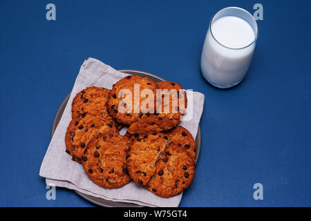 Essen Konzept - Nahaufnahme von Chocolate Chip Cookies auf eine Platte und ein Glas Milch. Stockfoto