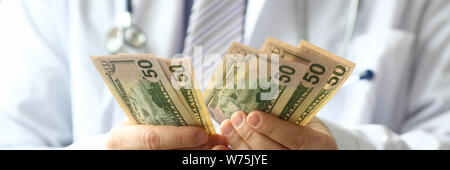 Männliche Hand des Arztes hald Dollar Cash in Hand Stockfoto