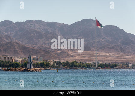 Aqaba, Jordanien - November 6, 2017: Blick auf den Leuchtturm und riesigen Flagge in den Hafen von Aqaba in Jordanien. Die Lage des Hafen zwischen Afrika und im Nahen und Mittleren Osten Stockfoto