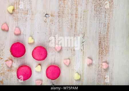 Macarons Erdbeeren und Marshmallows auf einem hölzernen Hintergrund. Stockfoto