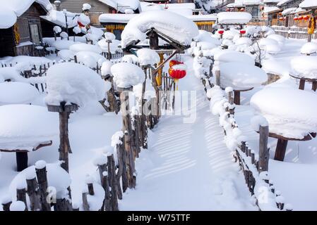 Schnee bedeckt Blockhütten und jetzt Pilze' in der touristischen Ortschaft Xuexiang Dorf, was wörtlich bedeutet Snow Village, Hailin city, M gesehen werden Stockfoto