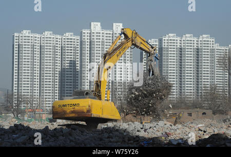 ---- Ein Bagger gräbt Betonstahl Stangen auf die Trümmer des verfallenen Häuser für die Neugestaltung in Changchun Stadt demoliert, North China Shanx Stockfoto